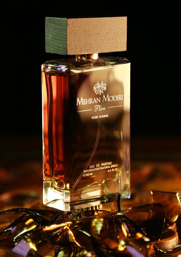 Stylish photo of Mehran Modiri Plan pour homme perfume on reflective surface.